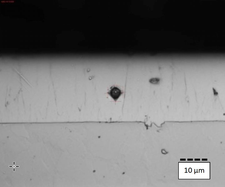 This cross section shows the Vickers hardness measurement on a piston rod sample after grinding.  